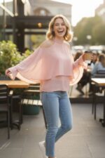blusa a strati di chiffon rosa chiaro con spalle scoperte e maniche ampie e svasate