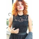abito nero elegante senza maniche, caratterizzato da un corpetto in pizzo con scollo alto e una gonna a balze in tulle
